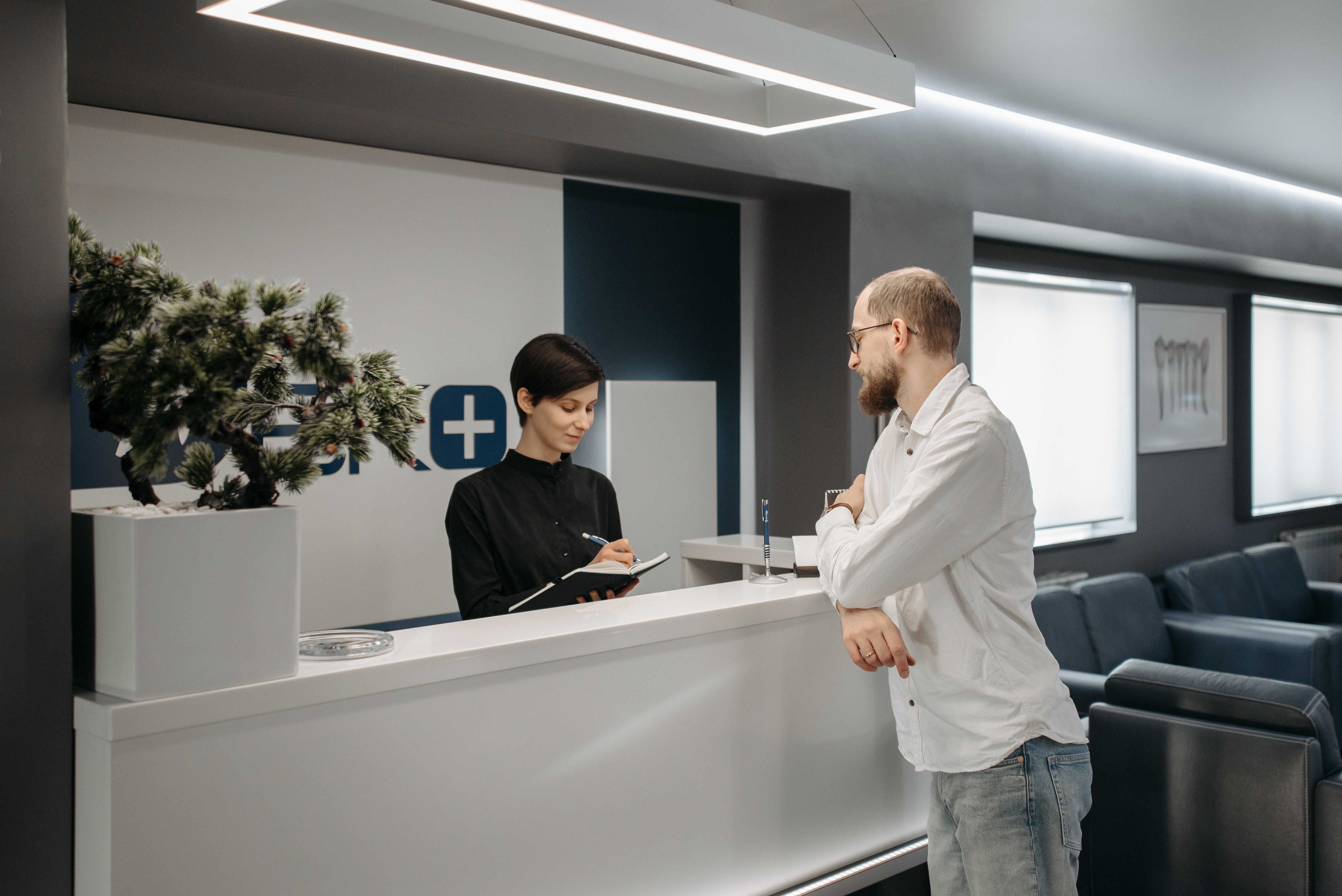 patient booking appointment at reception desk